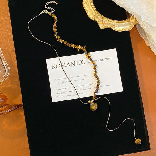 Product image 2 showing a small brown oval bead and slim drop on a silver tone chain