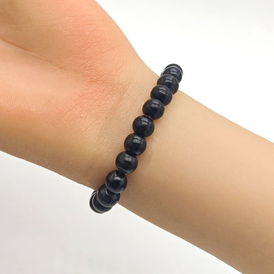 Black wood bead bracelet worn on a mannequin wrist close-up