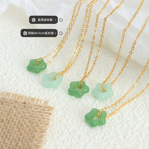 Several green star pendants on gold chains with material labels