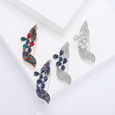 Blue Leaf, Multicolor Leaf, Navy Leaf, Clear Leaf brooch styles arranged on a light display