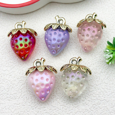 Iridescent strawberry charms arranged on a light background