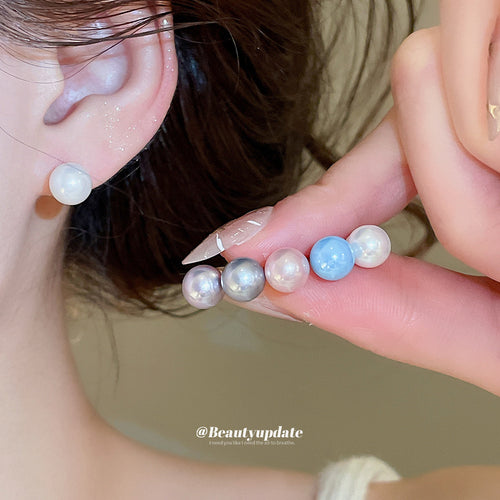 White pearl stud worn with multicolor pearl balls held on fingers
