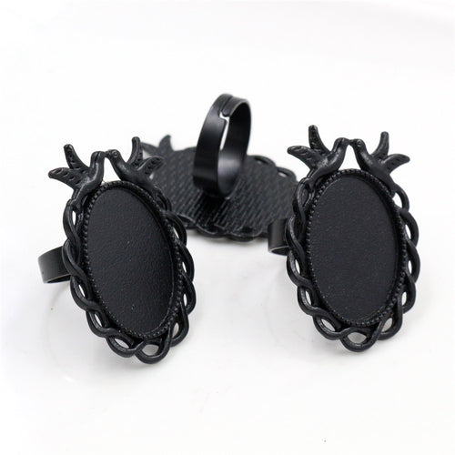 Grouped detail view of ornate oval adjustable ring settings with bird and scroll frame details