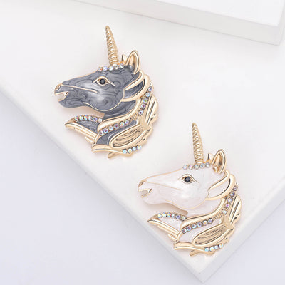 Gray Unicorn, White Unicorn brooch styles arranged on a light display