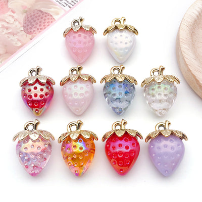 Iridescent strawberry charms arranged on a light background