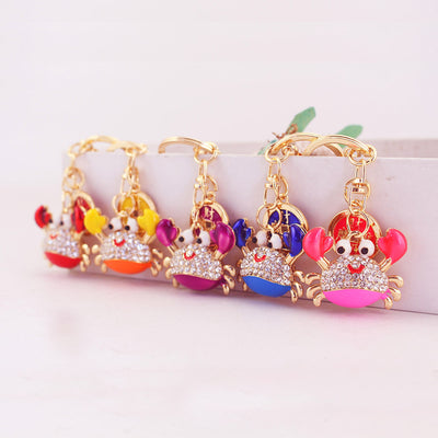 Five colorful crab keychains with clear rhinestones displayed in a row.