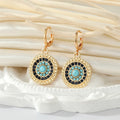 Gold Tone Crystal Turquoise Sun and Evil Eye Huggie Earrings view 4