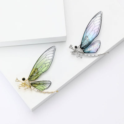 Front view of the translucent wing dragonfly brooch in blue and green brooch and its color options