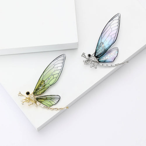 Front view of the translucent wing dragonfly brooch in blue and green brooch and its color options