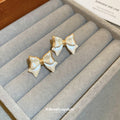 White Enamel Bow Stud Earrings With Gold Tone Edges view 4