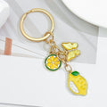 Gold-Tone Enamel Lemon Keychain With Citrus Slice Flower And Butterfly Charms view 3