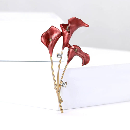 Red enamel three calla lily brooch on white display blocks