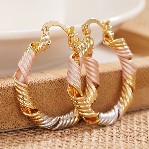 gold, silver, and rose gold tones earrings showing round hoops formed from twisted contrasting strands