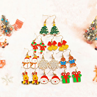 Nine pairs of enamel Christmas earrings arranged on white fur background