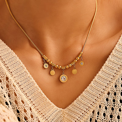 Gold Roman numeral disc charm necklace worn at collarbone