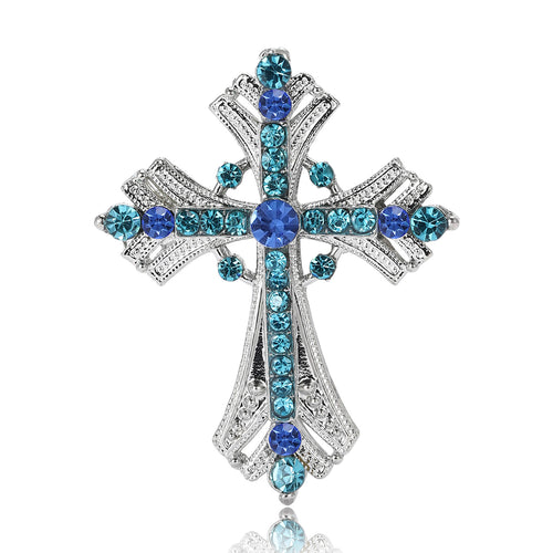 Front view of the ornate cross brooch showing an ornate silver-tone cross set with clear and colored crystals