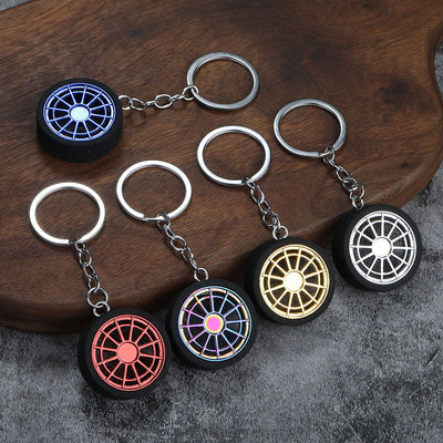 Five wheel keychains with gold, silver, red, blue, and iridescent spoked centers.