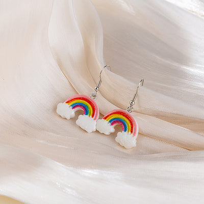 Rainbow cloud resin drop earrings on cream sheer fabric folds