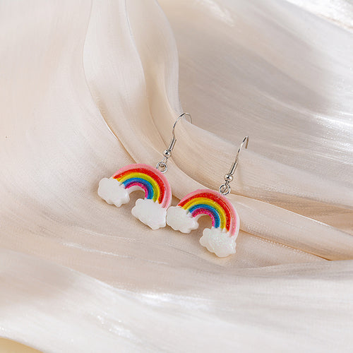 Rainbow cloud resin drop earrings on cream sheer fabric folds
