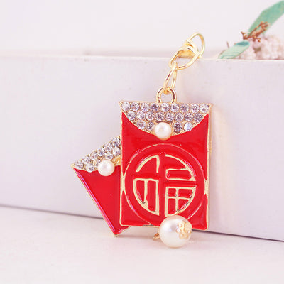 Front view of a red envelope Fu keychain with clear rhinestones and pearl-like accents.