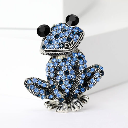 Blue crystal sitting frog brooch with black eyes close up