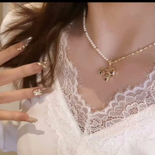 Horse pendant necklace with pearl half-chain worn at neckline