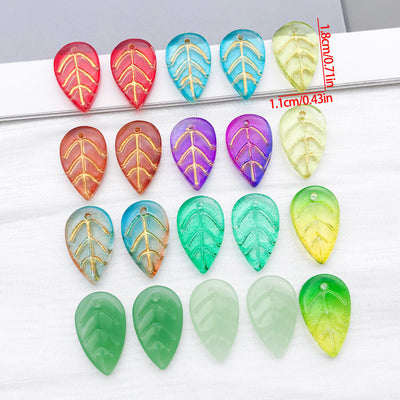 Gold tone edged glass leaf charms arranged as a full product overview
