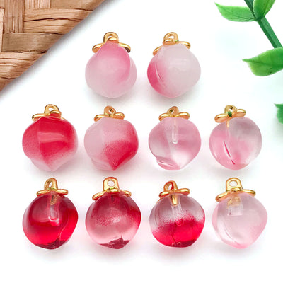 Front product photo of two-tone peach glass charm collection with green leaves showing the pictured design arrangement