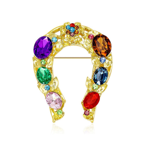 Gold horseshoe brooch with multicolor oval rhinestones on white