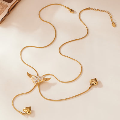Gold winged heart lariat necklace with dual heart drops flat lay
