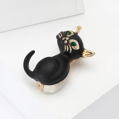 Angled display of the black enamel sitting cat brooch with green crystal eyes