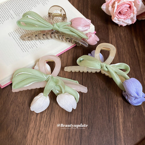 green satin bow tulip hair claw with pink, white, or purple flowers shown worn in a styled second view