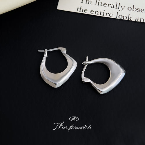 Irregular silver huggie hoops on black leather