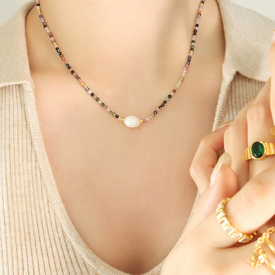 Multicolor stone bead pearl necklace worn on beige top