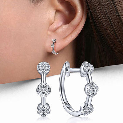 Front product view of silver tone hoop earrings with three round clear stone stations