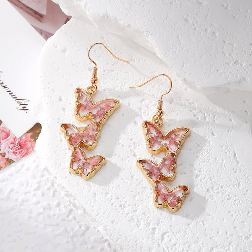 Pink pressed flower triple butterfly gold dangle earrings on white stone