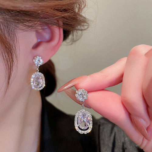 Silver Tone Oval Halo Floral Cluster Drop Earrings shown in styled view