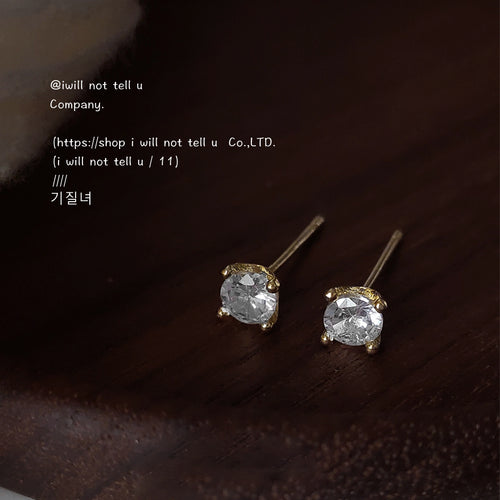 Gold clear crystal stud pair on dark wood surface close view