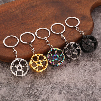 Five wheel-design keychains in silver, gold, rainbow, gunmetal and black finishes.
