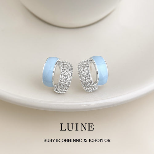 Light blue enamel crystal pave half hoops on white saucer