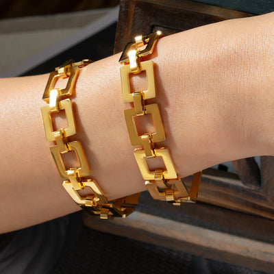 Wrist wearing gold square open-link chain bracelet double wrap style