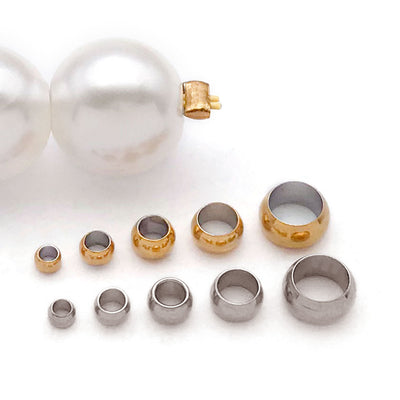 Gold-tone crimp bead jewelry findings arranged on a light background