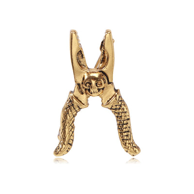 Antique gold skull pliers tool brooch on white background