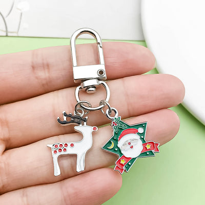 Image 1 showing a person holding two christmas themed key chains.