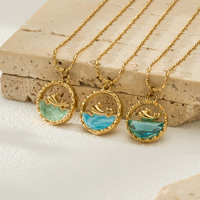 Neckline view of gold tone ocean scene round pendant necklaces in main image 1.