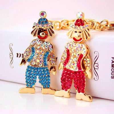 Two gold-tone clown keychains with blue and pink faceted accents displayed side by side.