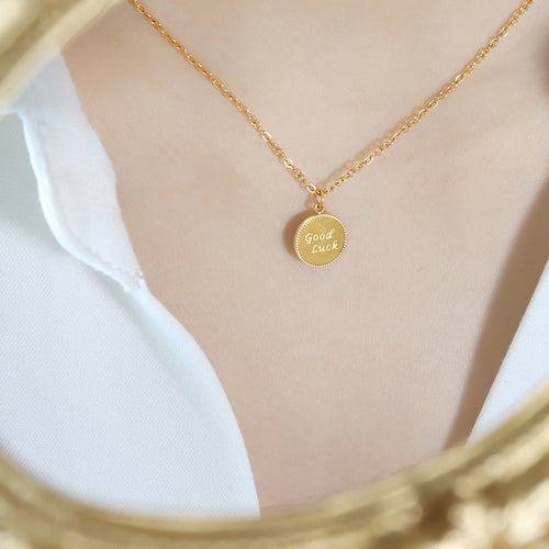 Gold Good Luck round disc pendant necklace worn white shirt