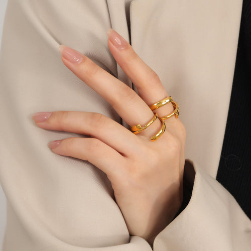 Model hand wearing two gold open double band crossover rings