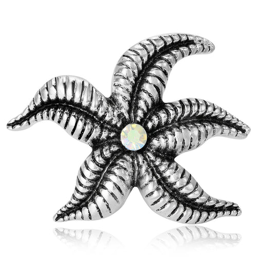 Silver textured starfish brooch with center AB crystal on white