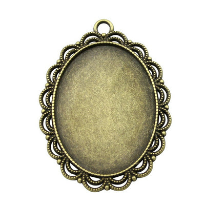 Close view of scalloped oval bezel pendant trays in two antique finishes